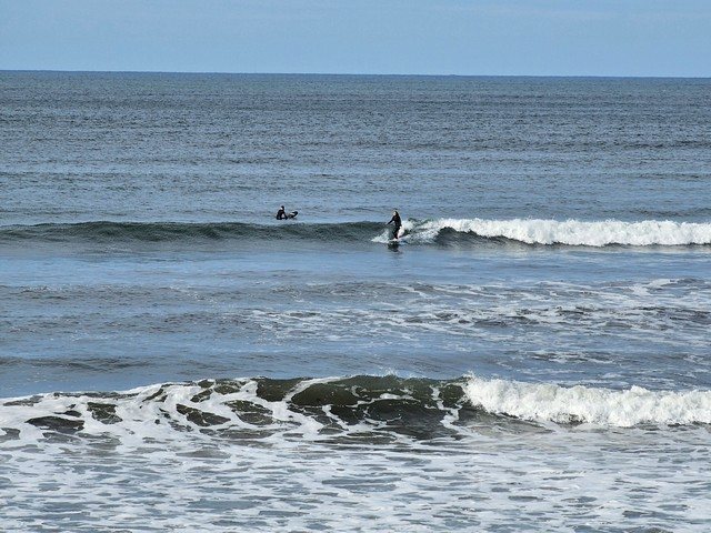 Surfer on a shoulder high wave in front of the shop
